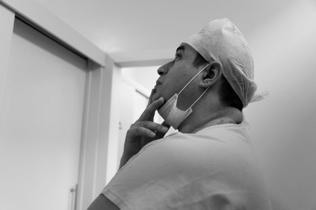 Thoughtful doctor in mask and uniform